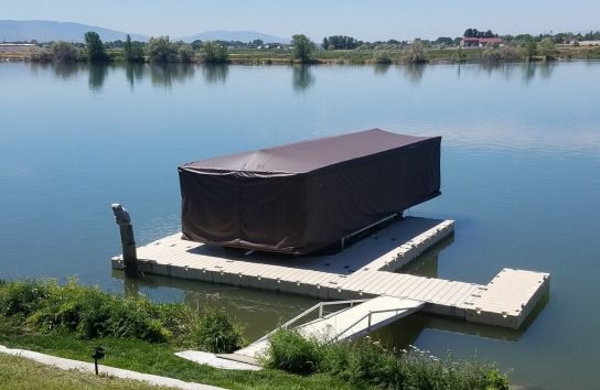Pontoon boat on a floating dock with the touchless boat cover